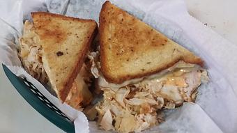 Product: A Spin off from the Classic Reuben. 100% all natural Turkey Breast Thinly Sliced grilled & piled high with cole slaw on grilled Rye bread with melted Swiss cheese and Thousand Island dressing - Surfwiches Sandwich Shop in Jacksonville Beach - Jacksonville Beach, FL American Restaurants