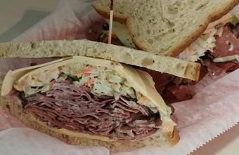 Product: Top Round Corn Beef thinly sliced and piled high, Swiss cheese, Coleslaw & Thousand island on Old Fashion Rye Bread. An old style Deli favorite - Surfwiches Sandwich Shop in Jacksonville Beach - Jacksonville Beach, FL American Restaurants