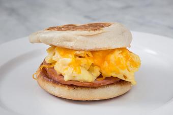 Product: Canadian Bacon and one scrambled egg on a toasted English muffin. 
Tempt Restaurant - New Orleans French Quarter - Tempt in French Quarter / CBD - New Orleans, LA American Restaurants