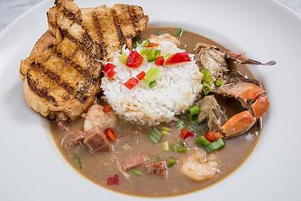 Product: Traditional New Orleans style roux with local shrimp, blue crab, oysters and andouille sausage. Served with toast points in a bowl.  Tempt Restaurant - New Orleans French Quarter - Tempt in French Quarter / CBD - New Orleans, LA American Restaurants