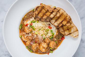 Product: Gulf shrimp swimming in a Cajun BBQ sauce over creamy southern-style grits.  Tempt Restaurant - New Orleans French Quarter - Tempt in French Quarter / CBD - New Orleans, LA American Restaurants