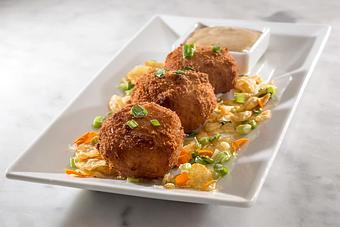 Product: 3 southern-style grit cakes stuffed with Boursin cheese and breaded in Zapps Voodoo chips. Fried and served with a pesto remoulade..   Tempt Restaurant - New Orleans French Quarter - Tempt in French Quarter / CBD - New Orleans, LA American Restaurants