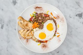 Product: Southern-style grits with slow braised roast beef shredded and smothered in a red wine demi-glace and topped with 2 eggs. Served with toast points..   Tempt Restaurant - New Orleans French Quarter - Tempt in French Quarter / CBD - New Orleans, LA American Restaurants