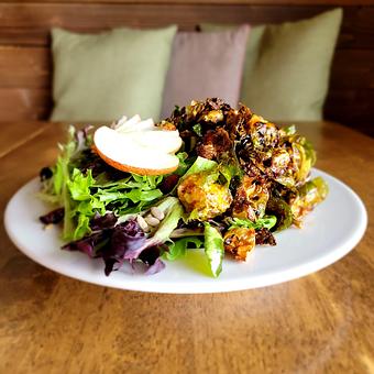 Product: Crispy brussels sprouts over mixed greens, dried cranberries, apples, sunflower seeds and balsamic drizzle. - The Acre in Albuquerque, NM American Restaurants
