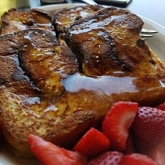 Product: Housemade Cinnamon Swirl French Loaf soaked overnight to custardy perfection.  Served with our pancake syrup or Pure Maple Syrup upon request. - The Back Door Bakery & Cafe in Sunland, CA American Restaurants