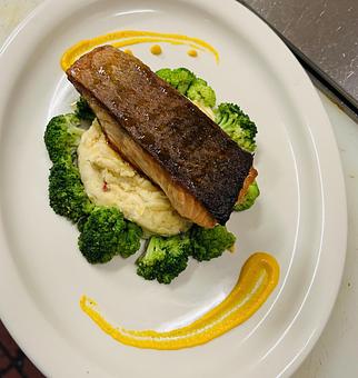 Product: Grilled Atlantic salmon seated atop a bed of lobster mashed potatoes and
surrounded by broccoli finished with a honey glaze. - The Bowman in Parkville, MD American Restaurants