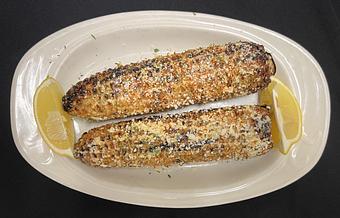 Product: Grilled corn on the cob featuring Sriracha mayo, fresh cilantro, tajin seasoning (a blend of dried chiles peppers, lime, and sea salt), and cotija cheese. - The Bowman in Parkville, MD American Restaurants