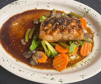 Product: Atlantic Salmon seated on a bed of mixed vegetables (carrot, broccoli, green beans and mushroom) and finished with a honey-soy sauce. - The Bowman in Parkville, MD American Restaurants