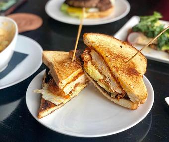 Product: spicy fried chicken breast, pickles & iceberg on toasted Texas toast - The Pressed Penny Tavern in Kansas City, MO American Restaurants