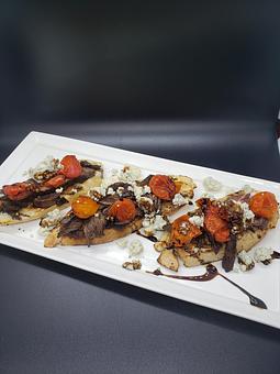 Product: blistered cherry tomatoes, a balsamic reduction & bleu cheese on grilled baguette
French bread [with the added hanger steak for $6 extra] - The Pressed Penny Tavern in Kansas City, MO American Restaurants