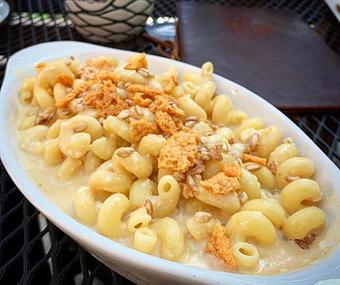 Product: cavatappi pasta, sweet potato mornay, crispy farro, toasted parmasen & a spicy brown
sugar syrup - The Pressed Penny Tavern in Kansas City, MO American Restaurants