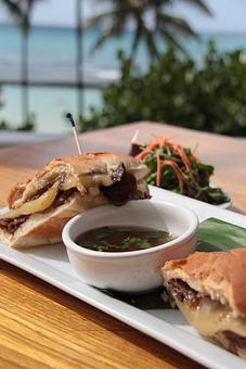 Product: Thin slices of juicy prime rib smothered in Swiss cheese & wasabi aioli on freshly baked and toasted bread. Served with pho dipping jus - Tikis Grill & Bar in Waikiki - Honolulu, HI Bars & Grills