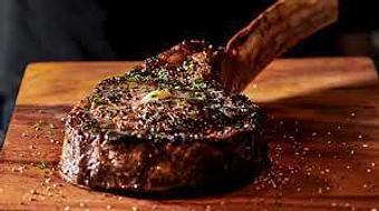 Product: So Big the bone hangs off the plate. - Tomahawk Steak, Chops, and Seafood in San Ramon, CA American Restaurants