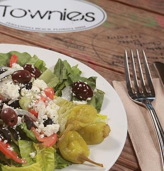 Product: This is a rough country Greek salad of crisp Lettuce, juicy Tomatoes,  quick Pepperoncini, sliced Onion,  plump Kalamata olives crumbly feta cheese and our Greek Vinaigrette. - Townies Pizzeria in Fernandina Beach, FL Italian Restaurants