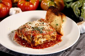 Product: prime beef bolognese, italian pork sausage, herbed ricotta, fresh basil, oregano, tomato sauce, mozzarella + parmesan cheese, garlic bread - Washington Prime in South Norwalk, CT American Restaurants