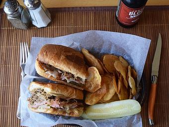 Product: Thursday Special - Cubano - Slow roasted pork, ham, Swiss, sliced pickles, brown mustard, grilled on a hoagie bun - West Allis Cheese & Sausage Shoppe in West Allis, WI Coffee, Espresso & Tea House Restaurants