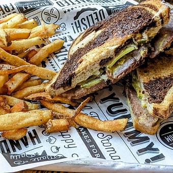 Product: House-brined Fox Heritage Farm beef brisket, Belgioioso provolone cheese, housemade sweet & spicy pickles, and mustard on Clasen’s marble rye. Served with choice of side. - Longtable Beer Cafe in Downtown Middleton - Middleton, WI American Restaurants