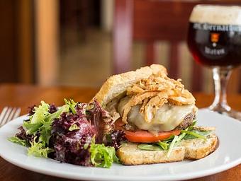 Product: Highland Spring Farm grass-fed beef, St. Bernardus Abt 12 beer battered onion straws, muenster cheese, lettuce, tomato, garlic aioli on toasted Madison Sourdough bread - Longtable Beer Cafe in Downtown Middleton - Middleton, WI American Restaurants