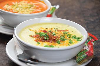 Product: Creamy potato soup topped with shredded cheddar cheese, crispy bacon, and chives. - Big Whiskey's American Restaurant & Bar in Springfield, MO Bars & Grills
