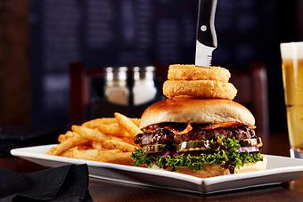 Product: Topped with golden onion rings, this mouthwatering burger is stacked with crisp bacon and smothered in our honey-whiskey BBQ sauce. - Big Whiskey's American Restaurant & Bar in Springfield, MO Bars & Grills