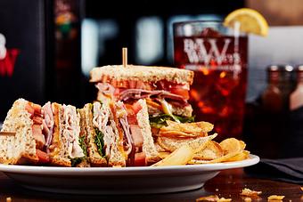 Product: Roasted turkey breast and hickory smoked ham piled high with apple wood smoked bacon, cheddar cheese, lettuce, tomato, and honey mustard on toasted berry wheat bread. - Big Whiskey's American Restaurant & Bar in Springfield, MO Bars & Grills