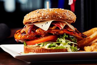 Product: Grilled chicken breast, smothered in BW’s Original Buffalo Sauce with shredded lettuce, tomato, and chipotle mayo. Topped with crisp bacon and melted swiss cheese and served on a wheat bun. - Big Whiskey's American Restaurant & Bar in Springfield, MO Bars & Grills