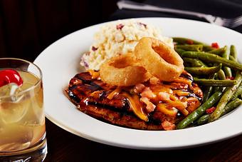 Product: Grilled chicken breast smothered with our honey whiskey BBQ sauce, melted cheddar cheese, fresh tomatoes and onion rings. Served with your choice of potato and steamed vegetables. - Big Whiskey's American Restaurant & Bar in Springfield, MO Bars & Grills