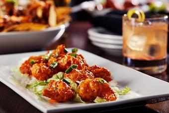 Product: Tender, crispy shrimp tossed in a light creamy and spicy sauce. Served over a bed of shredded lettuce and topped with green onions. - Big Whiskey's American Restaurant & Bar in Springfield, MO Bars & Grills