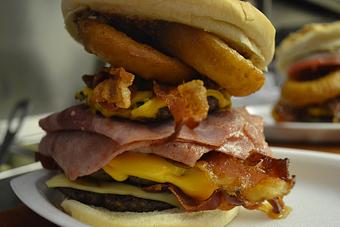 Product: A triple Cheeseburger is the foundation, then we add Ham, Bacon, Swiss and American Cheeses, two Beer-Battered Onion Rings, and top it all off with a scoop of our homemade Chili!  Come hungry! - Bob's Dairyland in Roan Mountain, TN American Restaurants