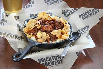 Product: Macaroni & cheese topped with Nueske’s
bacon & cheddar chili dog chili and garnished
with Fritos®. - Bricktown Brewery in Oklahoma City, OK Restaurants/Food & Dining