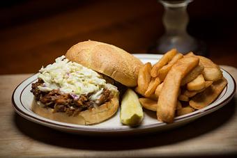 Product: Locally, smoked, tangy and tender pulled pork BBQ topped with homemade cole slaw - Chuck's Steak House in Restaurant Row - Myrtle Beach, SC Steak House Restaurants