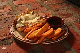 Product: thinly sliced Angus prime rib with melted mozzarella cheese, sauteed onions, au jus on the side and a toasted bun - Chuck's Steak House in Restaurant Row - Myrtle Beach, SC Steak House Restaurants