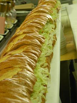 Product: One of our famous six foot subs, on freshly baked white bread, with lettuce, tomato, and pickle. Unbelievably delicious, and perfect for a party or picnic! - DG's Deli & Market in Albuquerque, NM Delicatessen Restaurants
