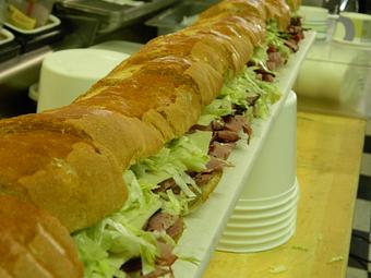 Product: One of our six foot subs made to order! This one has pastrami, cheese, mustard, mayo, lettuce, tomato, and pickle! So good, you'll be hard pressed to stop eating! - DG's Deli & Market in Albuquerque, NM Delicatessen Restaurants