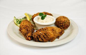 Product: 4 Jalapenos stuffed with blue claw crab cake fixins', Monterey Jack & cheddar cheeses, lightly battered & golden fried. Served with garlic Remoulade sauce - Eugene's Gulf Coast Cuisine in Houston, TX Seafood Restaurants