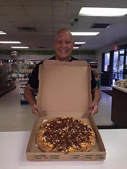 Product: Pictured is the owner "Farmer John" with his famous Breakfast Pizza - Farmer John's Food Market in Hammonton, NJ Delicatessen Restaurants