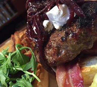 Product: 8oz Burger topped with Raspberry Chipotle Jam, Goat Cheese, Red Wine Onions, Arugula, and Bacon. - Foothills Brewing in Winston Salem, NC American Restaurants