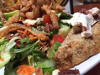 Product: Greens, toasted pecans, tomato, carrots, fried onion straws, bacon & veggie jack cheese. Spent grain toast points with cranberry goat cheese. - Foothills Brewing in Winston Salem, NC American Restaurants