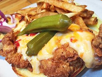 Product: Buttermilk marinated fried pork chop, ghost pepper pimento cheese, pickled okra, red onions and brown mustard on a brioche bun. - Foothills Brewing in Winston Salem, NC American Restaurants