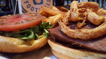 Product: Smoked beef brisket, Cherokee purple tomatoes, Worcestershire mayo, arugula and fried onions straws - Foothills Brewing in Winston Salem, NC American Restaurants