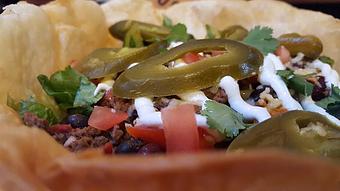Product: Giant taco salad with brewhouse chili, ghost jack cheese, pickled jalapenos, lettuce, tomato, sour cream and cilantro in a tortilla bowl. - Foothills Brewing in Winston Salem, NC American Restaurants