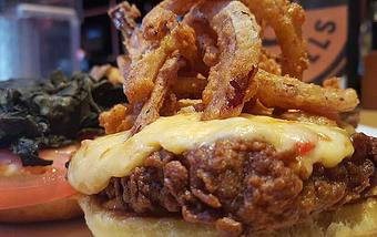 Product: Buttermilk fried pork chop, collard greens, pimento cheese and fried onion straws - Foothills Brewing in Winston Salem, NC American Restaurants