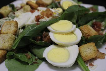 Product: Spinach Salad - Fresh spinach, bacon pieces, sliced egg, asiago cheese and croutons - Franconia Heritage Restaurant in Telford, PA American Restaurants