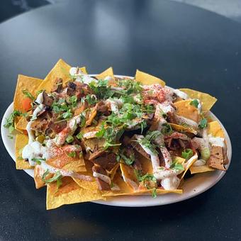Product: Nachos (Gluten free!)- House made chips covered in our own delicious nacho cheese sauce, sour cream, jalapeños, olives, fresh onions, tomatoes, and cilantro. - Highline Bar in Capital Hill - Seattle, WA Bars & Grills
