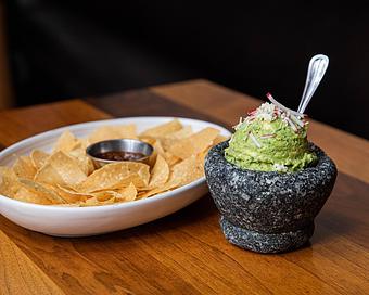 Product: housemade guacamole topped with radish and oaxaca cheese. served with housemade tortilla chips and roasted tomato salsa - Hub 51 in River North - Chicago, IL American Restaurants