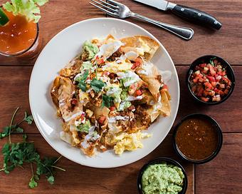 Product: housemade tortilla chips are layered with loads of oaxaca and white cheddar cheese and baked until melted. topped with roasted tomato salsa, jalapeno, cilantro, sour cream and soft scrambled eggs. - Hub 51 in River North - Chicago, IL American Restaurants