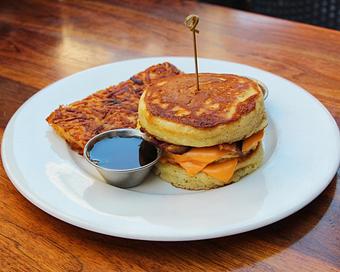 Product: soft scrambled eggs, american cheese and bacon sandwiched between two buttermilk pancakes. served with hash browns - Hub 51 in River North - Chicago, IL American Restaurants