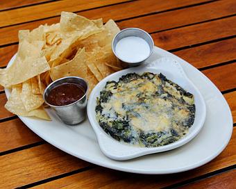 Product: gooey spinach and artichoke dip is baked until golden and bubbly. served with corn tortilla chips, roasted tomato salsa and sour cream - Hub 51 in River North - Chicago, IL American Restaurants
