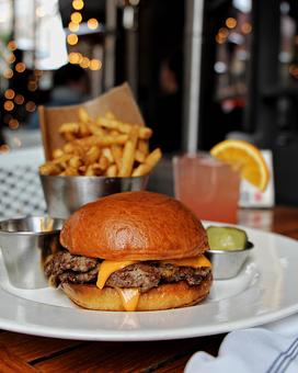 Product: two wagyu beef patties with melted american cheese in a sliced brioche bun. served with pickles, crispy Hub french fries and Hub secret sauce - Hub 51 in River North - Chicago, IL American Restaurants
