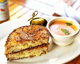 Product: toasted sourdough, parmesan reggiano, prairie breeze sharp cheddar and Wisconsin white cheddar cheeses, served with a cup of our creamy tomato soup and a side pickles - Hub 51 in River North - Chicago, IL American Restaurants